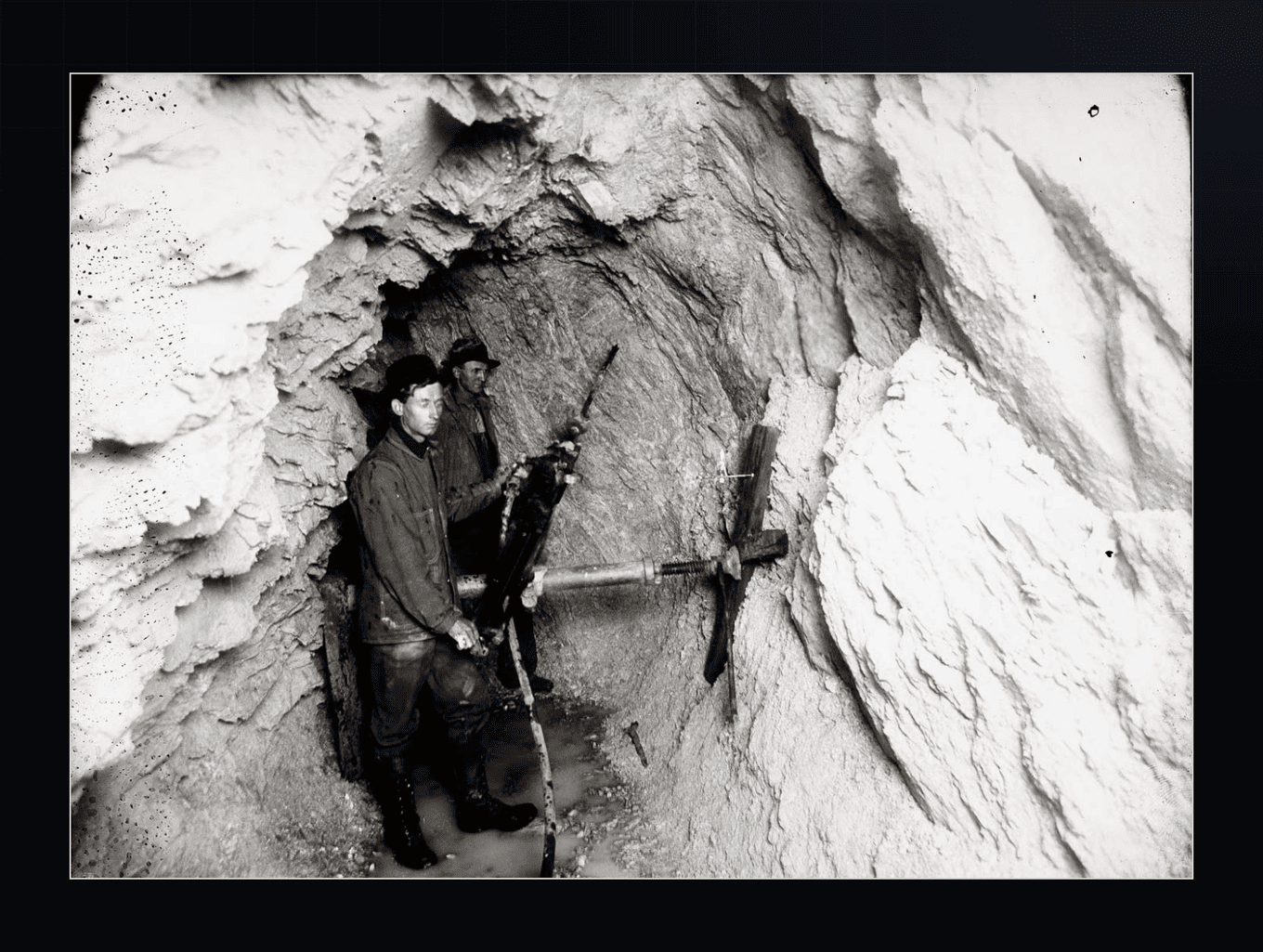 Two miners drilling underground in a stope, c. 1903.